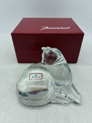 une image représentant une figurine en verre en forme d'oiseau, accompagnée d'une boîte rouge