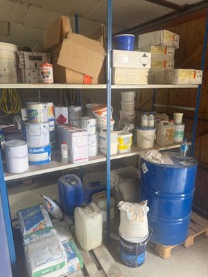 une étagère remplie de seaux et de pots de peinture