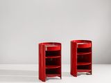 une paire de tables d'appoint rouges posées sur une surface blanche
