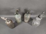 three glass bottles and a bottle with a handle on a gray surface