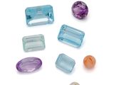 Plusieurs pierres de différentes couleurs sont disposées sur une surface blanche.
