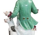 a figurine of a woman sitting on a toilet with a dog