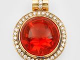 un pendentif composé d'une pierre rouge et d'un diamant sur fond blanc