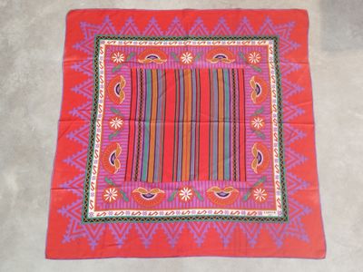 an image of a red table cloth with a colorful design on it