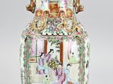 a vase with a painting on it sitting on a table