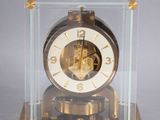 a clock that is in a glass case on a table
