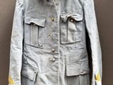 an old jacket hanging on a hanger on a wall