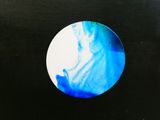 l'image d'une photo représentant un cercle bleu et blanc sur un fond noir