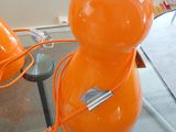 une lampe orange posée sur une table en verre
