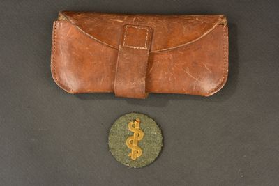 leather case with a dollar sign on it next to a coin