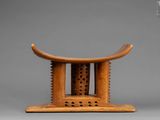 a small wooden stool with a carved design on top of it