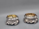 a pair of silverplated candlesticks with a design on the sides