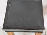 a small black table with a black top and wooden legs