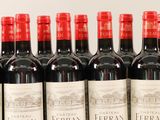 several bottles of red wine are lined up on a shelf