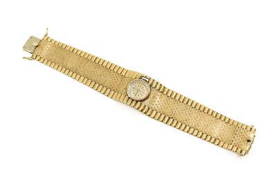 gros plan d'une montre en or sur une surface blanche