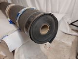 a roll of fabric on the floor next to a roll of tape