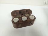 a wooden box with three jars in it on a table