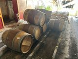 several wooden barrels are stacked on a pallet in a barn