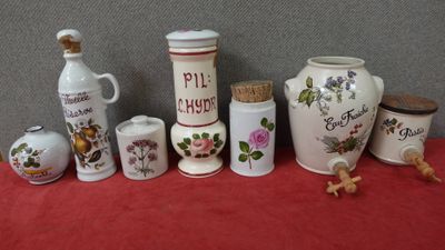 de nombreux vases et bocaux de toutes sortes posés sur une table rouge