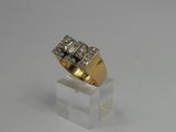 a gold and diamond ring on a clear acrylic stand