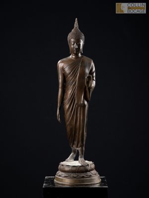 une statue en bronze représentant une personne debout sur un socle