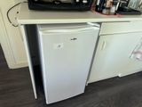 a small refrigerator in the corner of a small kitchen