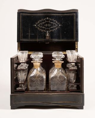 une boîte en bois contenant quatre bouteilles en verre et un miroir