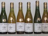 six bottles of wine are lined up in a row on a table