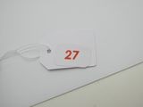 une étiquette portant le numéro 27, posée sur un morceau de papier