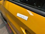 a close up of a yellow car with a sticker on it