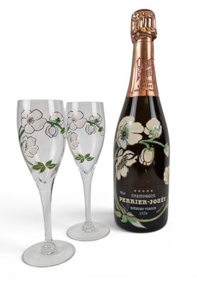 two wine glasses and a bottle of champagne next to each other