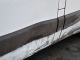 a picture of a dirty white van parked on the side of the road