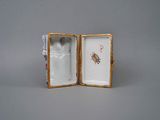 a small box with a figurine in it on a table
