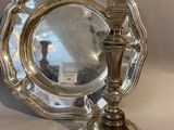 an image of a silver plate and a silver candle holder on a table