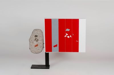 a red and white cabinet with a rock on it