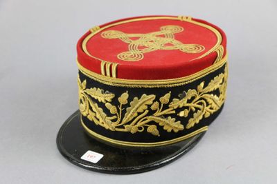 un chapeau rouge et noir orné de décorations dorées