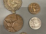 five medals on display on a table next to each other