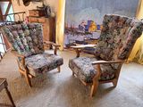 two chairs in a living room with a painting on the wall behind them