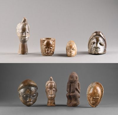 Plusieurs types de masques africains sont exposés sur un fond gris.