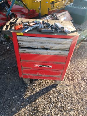 une boîte à outils rouge sur laquelle sont posés des outils
