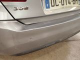 a close up of a silver car with a license plate on it