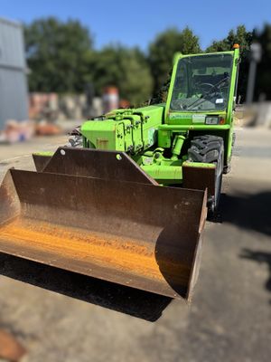 un tracteur vert qui est garé dans la terre