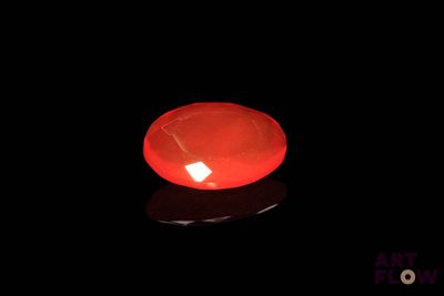 a lit candle in the dark with a black background