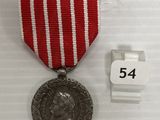 une image représentant une médaille ornée d'un ruban rouge et d'une médaille en argent