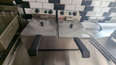 two deep fryers sitting on a counter in a kitchen