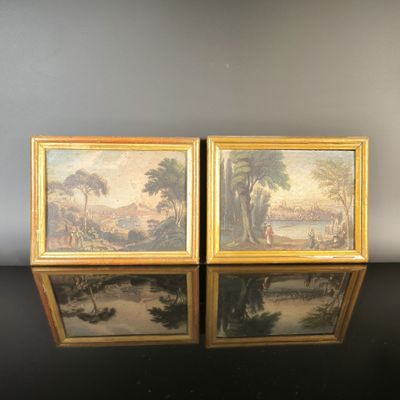 two framed paintings of a river scene with a man and a woman