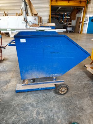 a blue container sitting on a dolly in a warehouse