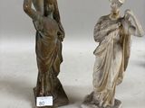 trois statues représentant une femme et un homme tenant une croix