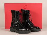 une paire de bottes militaires noires posée sur une boîte rouge