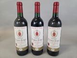 trois bouteilles de vin posées sur une table l'une à côté de l'autre
